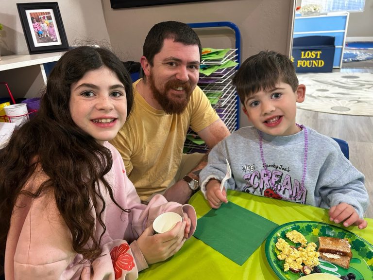 Reviews 7 Sunshine House parent with his children at a classroom breakfast event